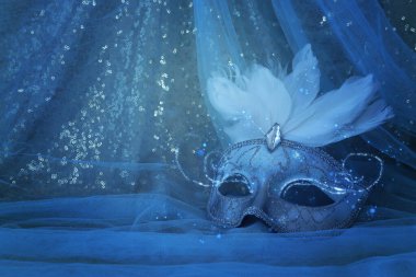 Mavi şifon arka plan üzerinde zarif ve narin beyaz Venedik maskesi fotoğrafı