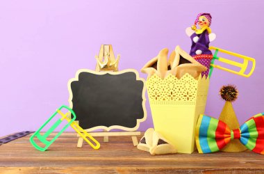 Ahşap masa ve mor arka plan üzerine Purim kutlaması konsepti (Yahudi karnavalı tatili)