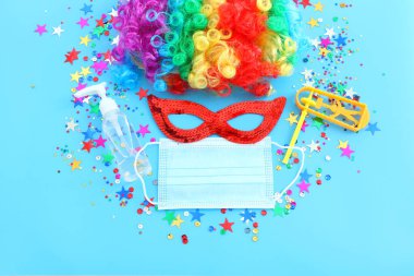 karnaval, parti ve Purim kutlaması (Yahudi karnavalı bayramı) mavi arka planda. Coronavirus önleme konsepti, tıbbi maske ve dezenfektan jeli