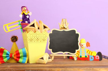 Ahşap masa ve mor arka plan üzerine Purim kutlaması konsepti (Yahudi karnavalı tatili)