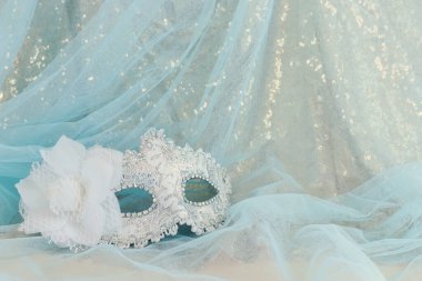 Altın ve mavi şifon arka planda zarif ve hassas Venedik maskesinin fotoğrafı