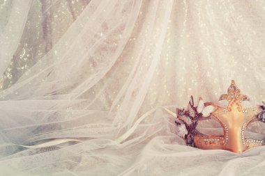 Altın ve mavi şifon arka planda zarif ve hassas Venedik maskesinin fotoğrafı