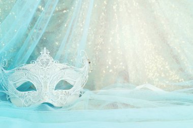 Altın ve mavi şifon arka planda zarif ve hassas Venedik maskesinin fotoğrafı