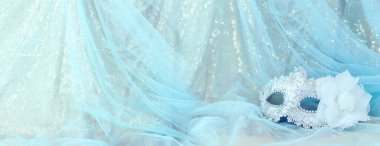 Altın ve mavi şifon arka planda zarif ve hassas Venedik maskesinin fotoğrafı