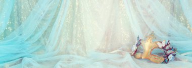 Altın ve mavi şifon arka planda zarif ve hassas Venedik maskesinin fotoğrafı