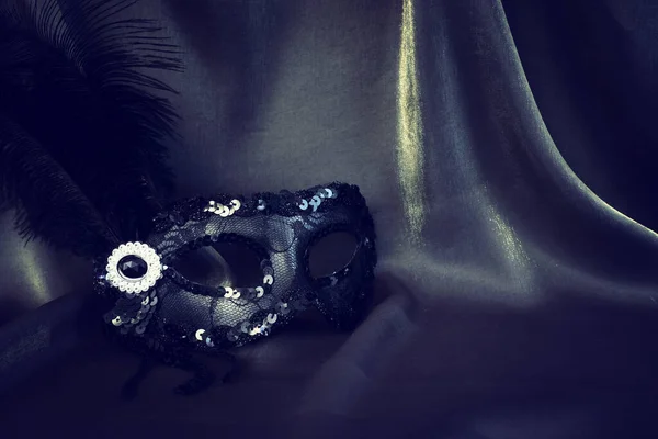 Zdjęcie Eleganckiej Delikatnej Czarnej Weneckiej Maski Nad Ciemnym Jedwabnym Tłem — Zdjęcie stockowe
