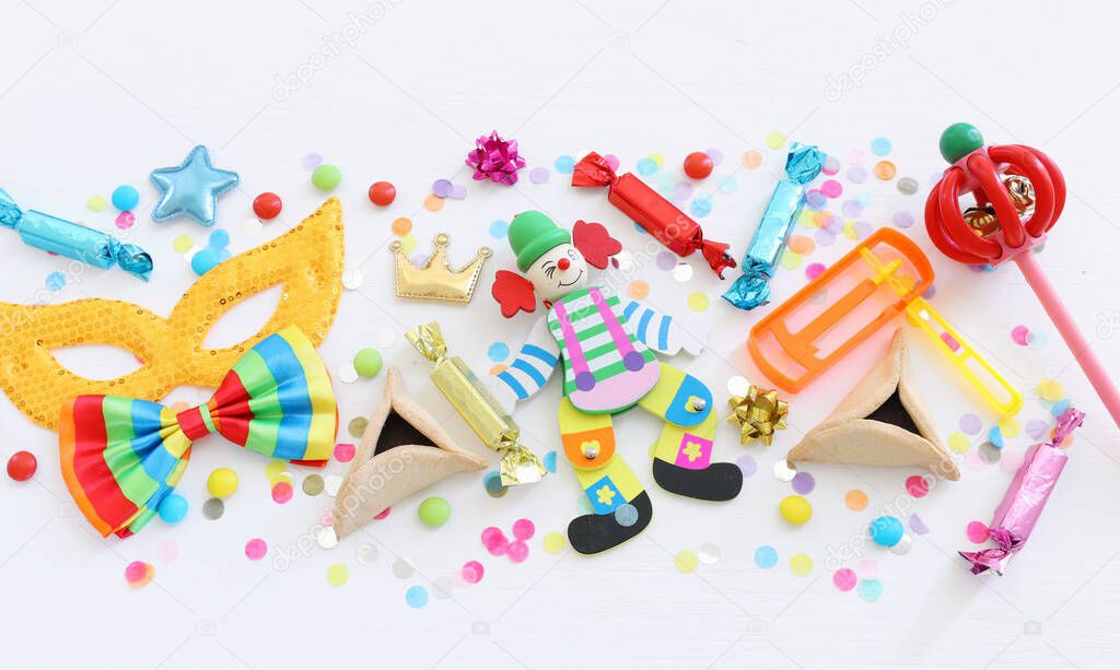 Purim celebration concept (jewish carnival holiday) over wooden white background. Top view, flat lay