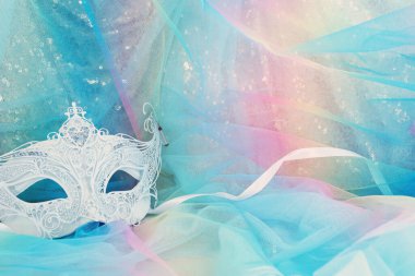 Altın ve mavi şifon arka planda zarif ve hassas Venedik maskesinin fotoğrafı