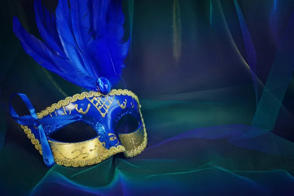 青のダークシフォンの背景にエレガントで繊細なヴェネツィアのマスクの写真 — ストック写真
