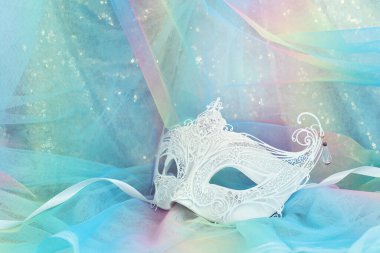 Altın ve mavi şifon arka planda zarif ve hassas Venedik maskesinin fotoğrafı