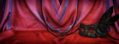 Kırmızı ipek arka planda zarif ve narin Venedik maskesi fotoğrafı