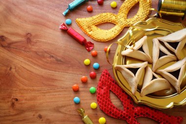 Ahşap arka planda Purim bayramı konsepti (Yahudi karnavalı tatili). Üst manzara, düz uzanma