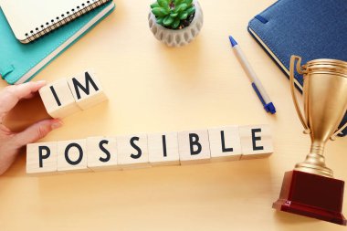 İnsan, imkansız metinle ahşap küpleri tutarak 