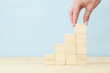 Harita ya da merdiven olarak ahşap blokları elle düzenleme. büyüme ve başarı kavramı