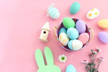 Paskalya renkli yumurtaların yanında tatlı tavşan pastel arka planda
