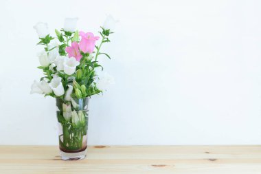 spring bouquet of white and pink bell flowers over purple wooden background