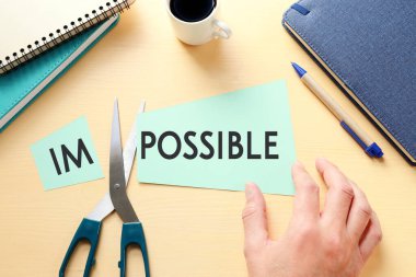 Erkek el ele tutuşma kartı. İmkânsız mesajla. Kelimeyi kesip mümkün kılmak. Başarı ve meydan okuma konsepti.