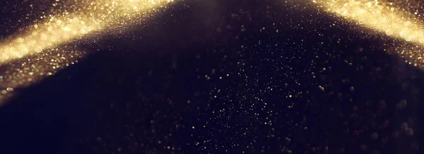 background of abstract gold and black glitter lights. defocused