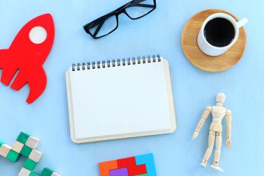 Tahta masadaki kahve fincanının yanında boş sayfalar olan açık defter resmi. Metin ya da model eklemeye hazır.