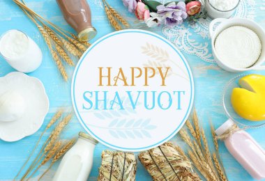 Top view photo of dairy products over blue wooden background. Symbols of jewish holiday - Shavuot clipart