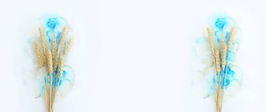 Artistik mürekkep arkaplanındaki güzel buğday ürünlerinin yaratıcı görüntüsü. Kopyalama alanı olan üst görünüm. Yahudi bayramının sembolleri - Shavuot