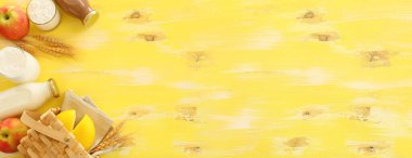 Süt ürünlerinin sarı ahşap arka plandaki en iyi görüntüsü. Yahudi bayramının sembolleri - Shavuot