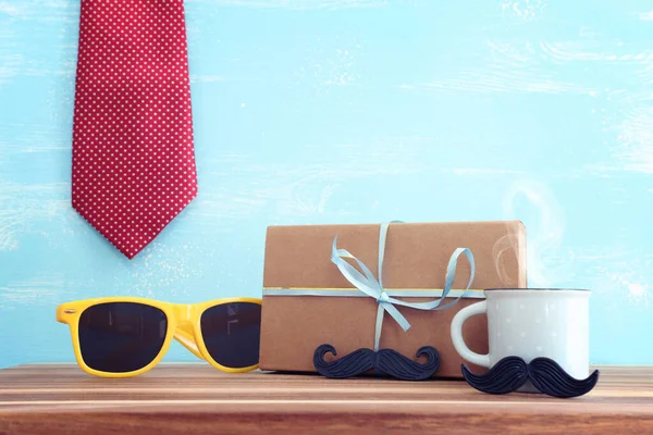 image of fathers day composition with hot cup of coffee over table and blue background