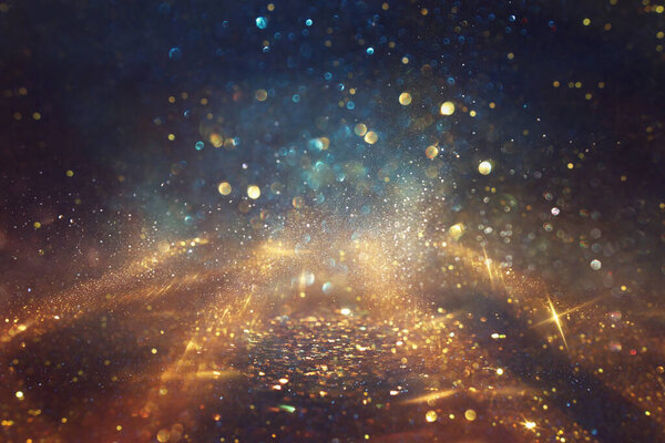Background of abstract glitter lights. gold, blue and black. de focused