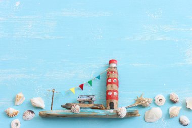 Deniz hayatı tarzı nesnelerin, tekne, dalgalı sahil evleri, deniz kabukları ve ahşap arka planda deniz yıldızları gibi deniz yaşamının en üst görüntüsü.