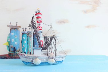 Tekne, dalgalı sahil evleri ve ahşap arka planda deniz kabukları gibi deniz hayatı tarzı nesnelerle ilgili denizcilik kavramı