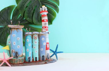 Deniz hayatı tarzı nesnelerin, tekne, dalgalı sahil evleri, deniz kabukları ve ahşap arka planda deniz yıldızları gibi deniz yaşamının en üst görüntüsü.