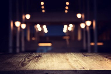 Soyut bulanık restoran ışıklarının önündeki ahşap masanın arkaplan resmi