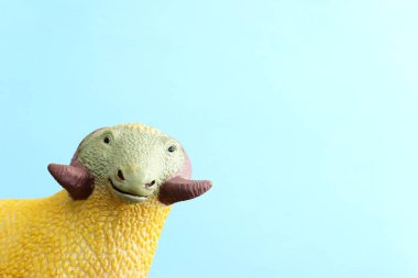 Ahşap mavi pastel masadaki lastik koyun oyuncağının komik arka planı