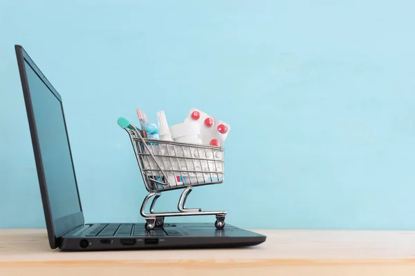 Shopping cart with pills . Purchase of medicines online. blue background