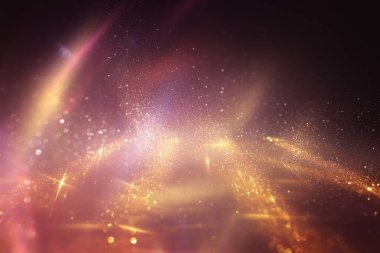 Soyut altın ve kırmızı parıltılı ışıkların arkaplanı. Odaklanamadı