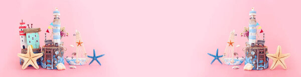 Nautical concept with sea life style objects as boat, driftwood beach house, seashells and starfish over pink pastel background