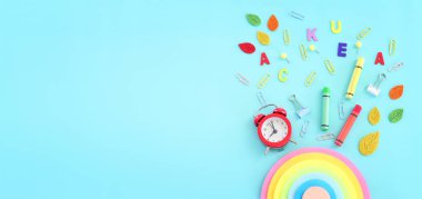 Eğitim ve okul konseptine geri dönüş. Kırtasiye malzemesi mavi arka planda. Üst görünüm, düz uzanma