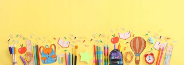 Okul konseptine geri dönelim. Pastel sarı arkaplan üzerindeki öğrenci kırtasiyesinin üst görünümü