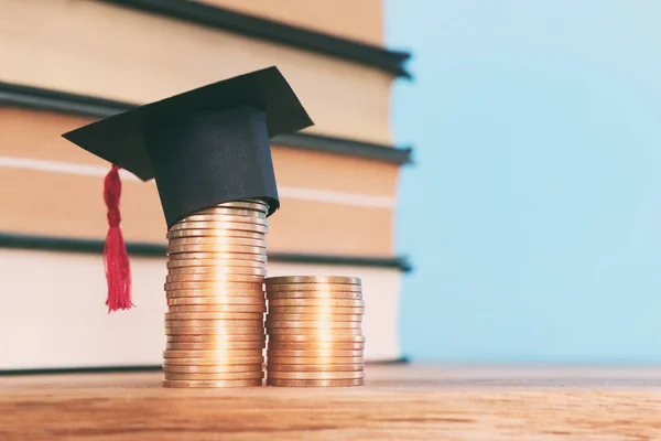 Schwarze Graduiertenmütze Über Einem Stapel Münzen — Stockfoto