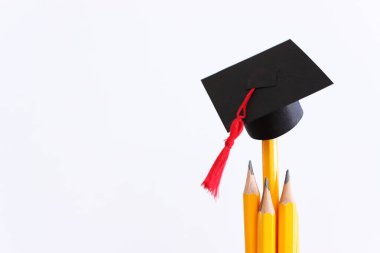 Eğitim konsepti imajı. Geleneksel mezuniyet şapkası kalemlerin üzerinde.