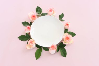 Pastel narin arka plan, pembe güller ve taç yapraklarıyla. Üst görünüm