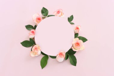 Pastel narin arka plan, pembe güller ve taç yapraklarıyla. Üst görünüm