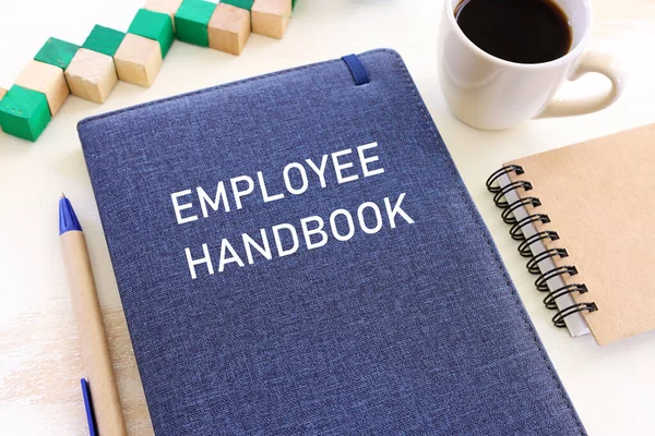 Concept image of employee handbook over wooden office table. top view