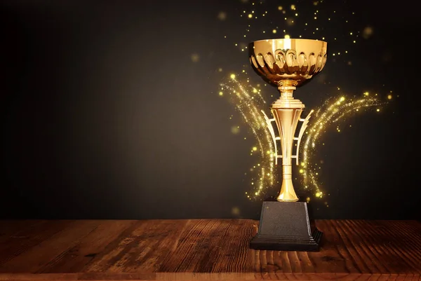 Altın Kupanın Loş Görüntüsü Ahşap Masa Koyu Arkaplan Üzerinde Soyut — Stok fotoğraf