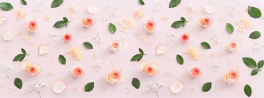 Pastel narin arka plan, pembe güller ve taç yapraklarıyla. Üst görünüm