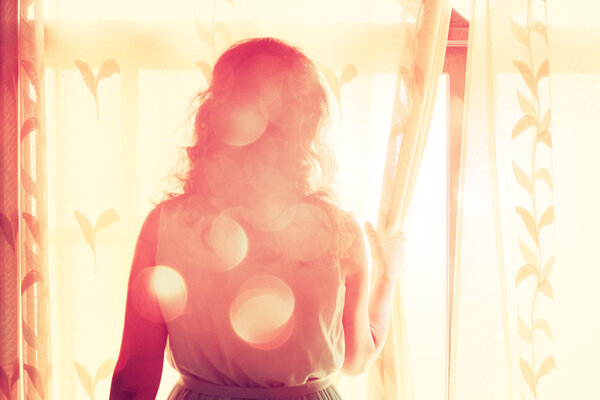Young woman near window waiting for someone
