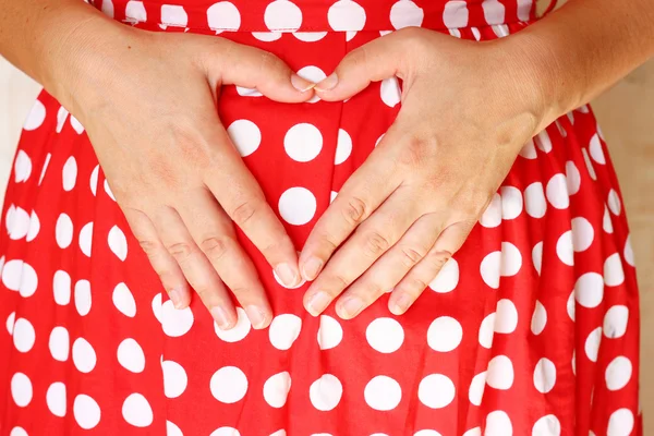 Image en gros plan d'une femme enceinte méconnaissable touchant son ventre avec ses mains — Photo