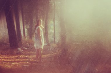 genç kadın ormanda ayakta gerçeküstü fotoğrafı. Görüntüyü dokulu ve tonda