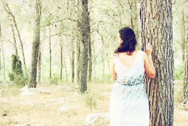 Сюрреалістична фотографія молодої жінки, що стоїть у лісі. зображення текстурується і тонується — стокове фото