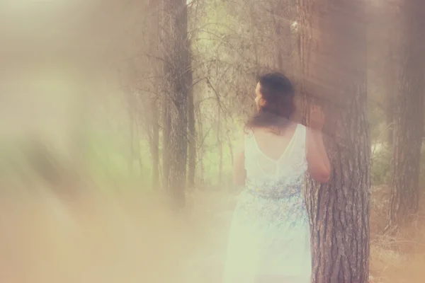 Foto surrealista de una joven de pie en el bosque. imagen es texturizada y tonificada —  Fotos de Stock